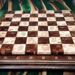 Шахова торцева дошка.
Матеріал дуб, берест, вільха, бук, ясен, клен.
Восьмиразовий розріз-склейка, лазерне гравіювання, тонування бойцами, нанесення золотої патіни